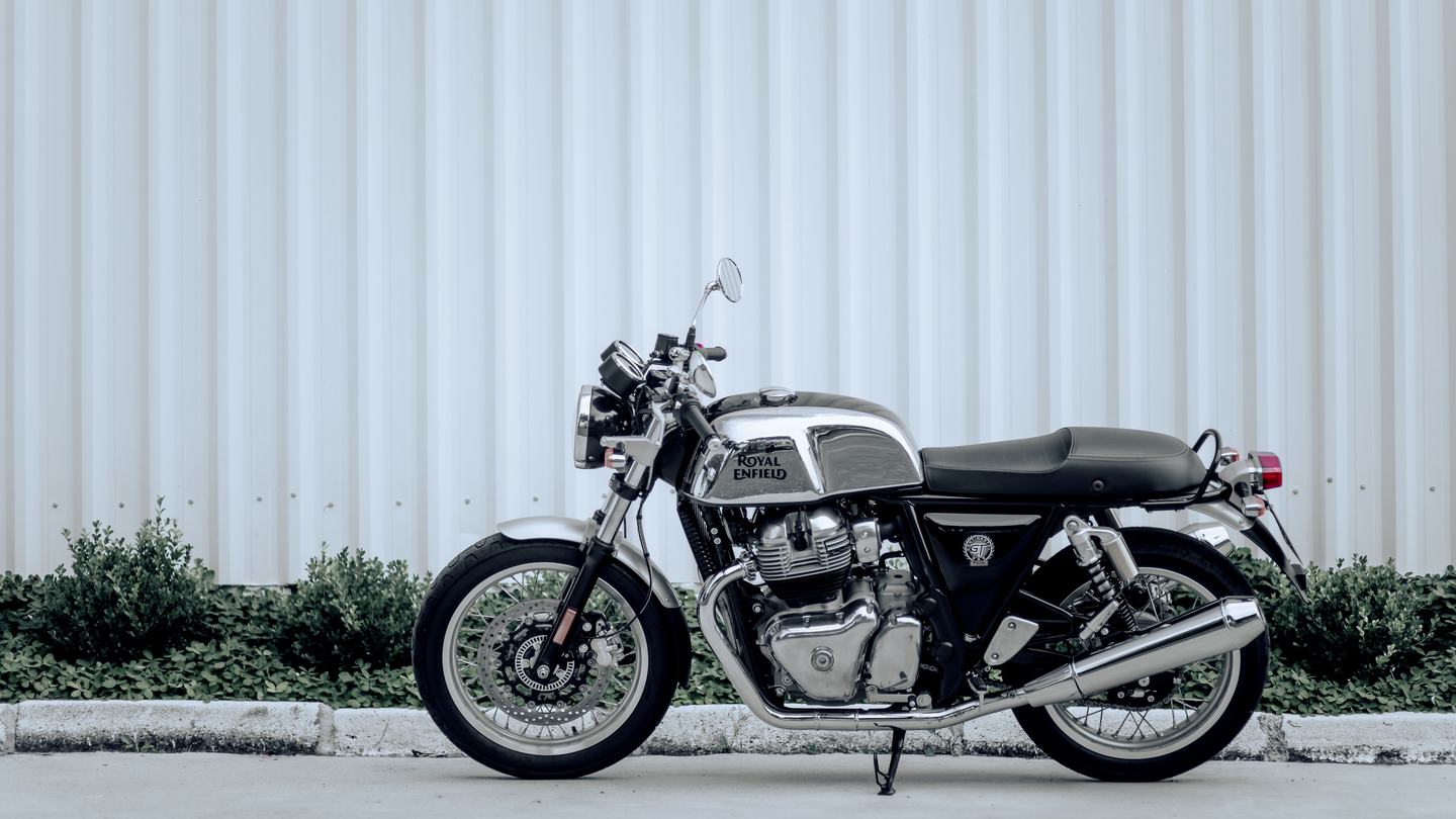 白い壁の前に停められたバイクの横姿